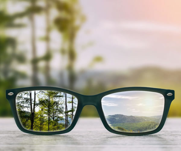 A view of clear glasses with a blurry background that depicts clarity